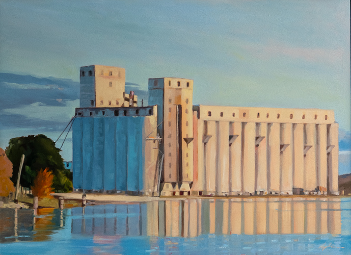 Oil on panel landscape painting of grain elevators reflected in calm harbour water, bathed in warm afternoon light with touches of autumn foliage, by Georgian Bay artist Joanna Aplin, Owen Sound Ontario.